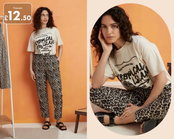 Woman wearing leopard print jersey trousers paired with a graphic t shirt and black sandals.