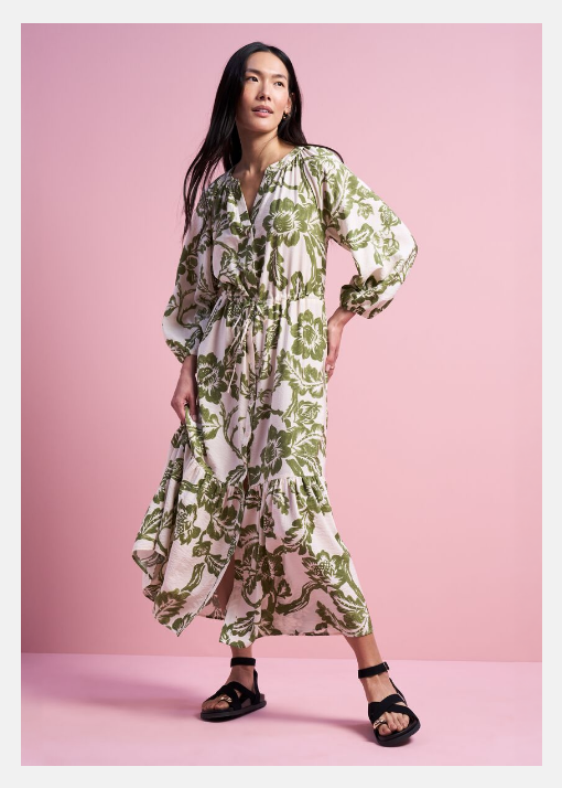 Spring Dresses. Model wearing a white and khaki floral printed midi dress with long sleeves, paired with black sandals.